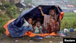 Rohingya refugees shelter from the rain in a camp in Cox's Bazar, Bangladesh, Sept. 17, 2017.