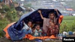 Rohingya refugees shelter from the rain in a camp in Cox's Bazar, Bangladesh, Sept. 17, 2017.