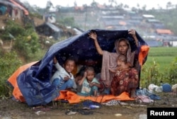Rohingya refugees shelter from the rain in a camp in Cox's Bazar, Bangladesh, Sept. 17, 2017.