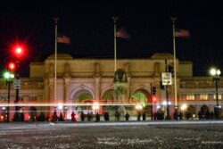 Birdwatchers line Columbus Circle in front of Union Station in Washington, Jan. 7, 2022, hoping for a glimpse of a rare snowy owl that has been seen there and around Washington's Capitol Hill neighborhood.