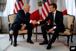 FILE - President Donald Trump shakes hands with French President Emmanuel Macron during a meeting at the U.S. Embassy, May 25, 2017, in Brussels.