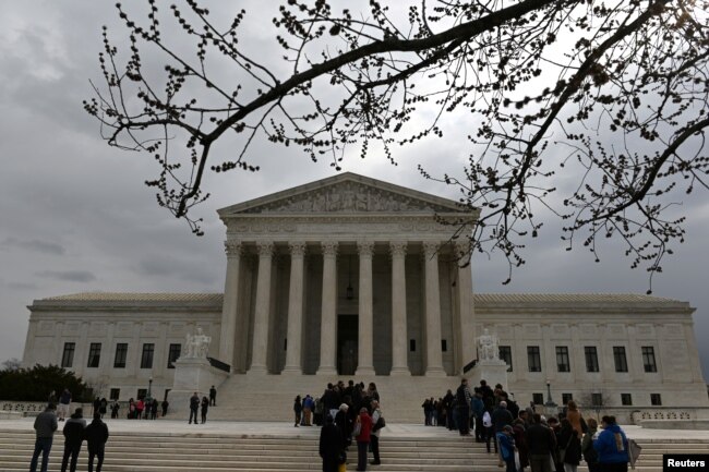 FILE - People wait in line outside the U.S. Supreme Court to hear the orders being issued, in Washington, U.S. March 18, 2019.