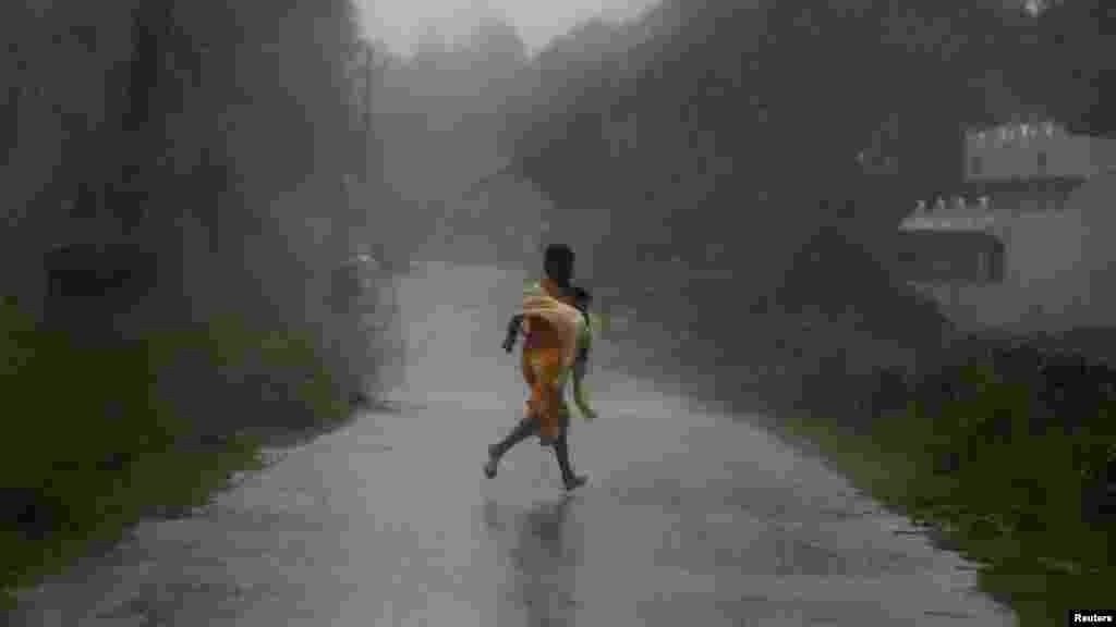 A girl runs for shelter in heavy rain brought by Cyclone Phailin in Ichapuram town in Srikakulam district in the southern Indian state of Andhra Pradesh.