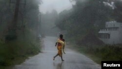 Une adolescente fuyant les pluies violentes du cyclone Phailin