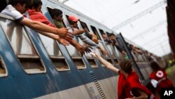 Para aktivis dari Palang Merah Hongaria membagikan air kepada migran di kereta api yang tiba dari Tovarnik, Kroasia di stasiun Zakany (foto: dok). Jalur kereta api Kroasia-Hongaria akan dibuka kembali setelah ditutup selama beberapa bulan. 