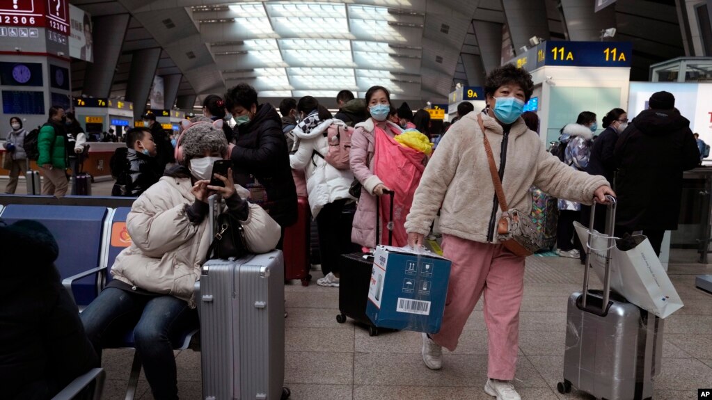 北京南站戴着口罩的旅客在候车室里等待。（2022年1月14日）(photo:VOA)