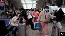 北京南站戴著口罩的旅客在候車室裡等待。（2022年1月14日）