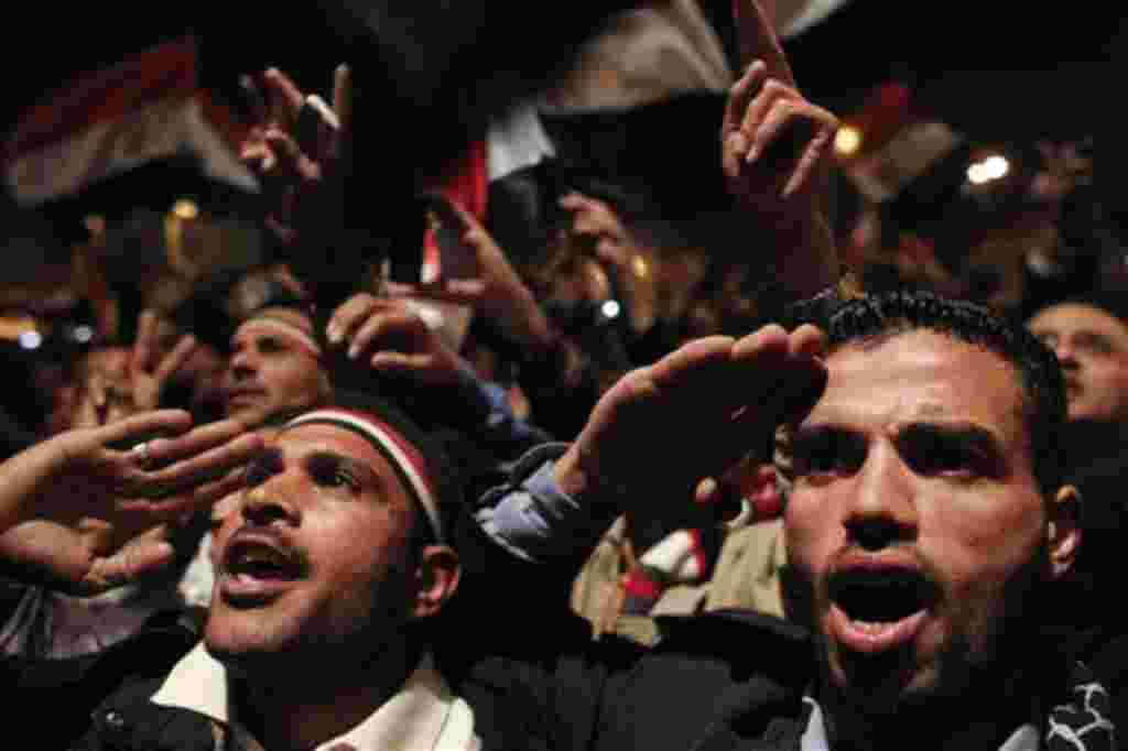 Manifestantes de la oposición contemplan el discurso televisado del ex presidente Mubarak.