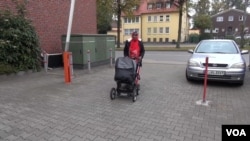 Somali migrant mother Rahma Abukar Ali walks her baby daughter, Sophia, in a stroller at a refugee center in a small German town near Düsseldorf, where she is awaiting a response to her application for asylum, Oct. 2015. (A. Osman/VOA)
