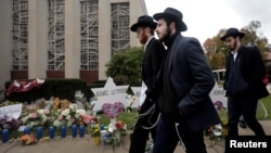 People walk past a makeshift memorial outside the Tree of Life synagogue following Saturday's shooting at the synagogue in Pittsburgh, Pennsylvania, Oct. 29, 2018. 
