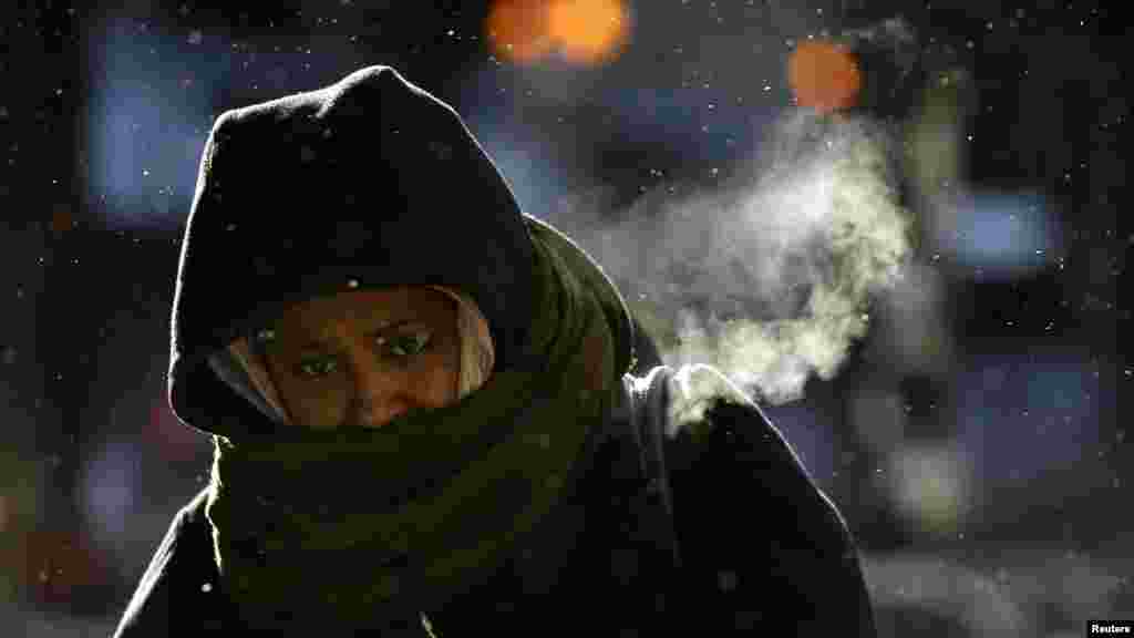 A woman walks in frigid cold temperatures though downtown Chicago, Illinois, Jan. 6, 2014. 