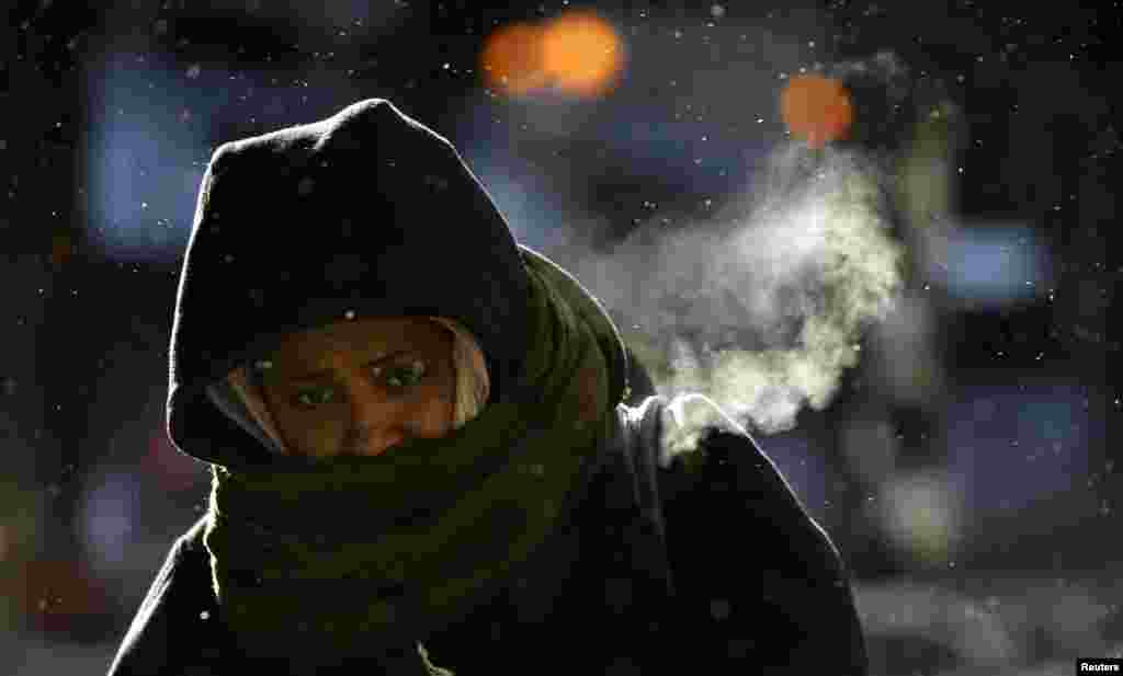 Uma mulher caminha entre temperaturas frígidas na baixa de Chicago, Illinois, Jan. 6, 2014. 