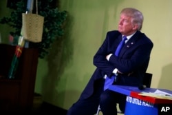 Then Republican presidential candidate Donald Trump listens to a question during a campaign event at Little Haiti Cultural Center, Sept. 16, 2016, in Miami.