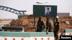 Syrian soldiers stand at the Naseeb border crossing with Jordan in Deraa, Syria, July 7, 2018. 