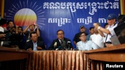 Sam Rainsy (C), president of the Cambodia National Rescue Party (CNRP) addresses reporters at his party's headquarters in Phnom Penh, July 29, 2013.