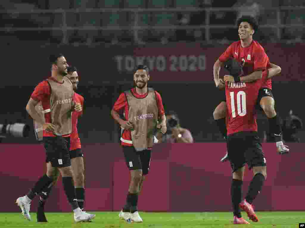 Egypt's Ammar Hamdy, right, is carried by teammate Ramadan Sobhi after he scored his side's second goal against Australia during a men's soccer match at the 2020 Summer Olympics, Wednesday, July 28, 2021, in Sendai, Japan. (AP Photo/Andre Penner)