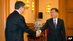 U.S. Treasury Secretary Jacob Lew, left, shakes hands with Chinese Vice Premier Wang Yang as he arrives for a meeting at the Zhongnanhai Leadership Compound in Beijing Monday, March 30, 2015.