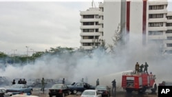 Firefighters trying to extinguish a fire after a bomb blast at the parking lot of police headquarters in Abuja, Nigeria, June 16, 2011