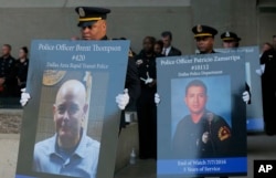 Honor guard carry portraits of fallen officers during a candlelight vigil at City Hall, July 11, 2016, in Dallas.