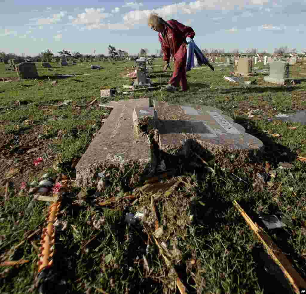 Claudia Clark clears tornado debris from a cemetery, May 22, 2013, in Moore, Oklahoma.