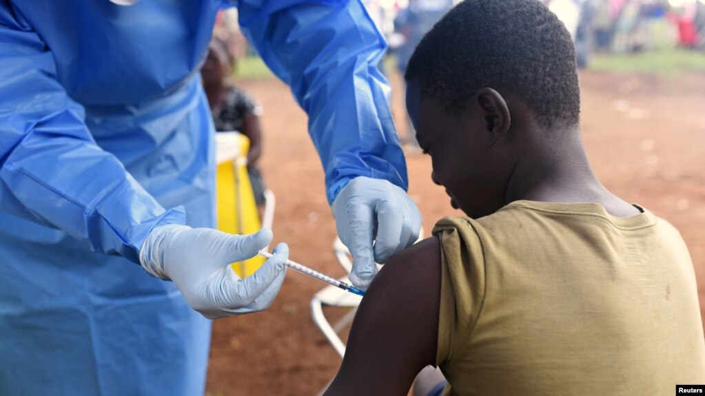 A Congolese health worker administers Ebola vaccine to a boy who had contact with an Ebola sufferer in the village of Mangina in North Kivu province of the Democratic Republic of Congo, August 18, 2018. (REUTERS/Olivia Acland)