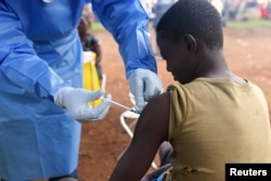 FILE - A Congolese health worker administers Ebola vaccine to a boy who had contact with an Ebola sufferer in the village of Mangina, in North Kivu province of the Democratic Republic of Congo, Aug. 18, 2018.