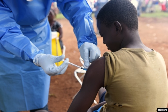 FILE - A Congolese health worker administers Ebola vaccine to a boy who had contact with an Ebola sufferer in the village of Mangina, in North Kivu province of the Democratic Republic of Congo, Aug. 18, 2018.