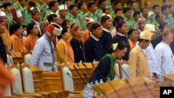 National League for Democracy (NLD) leader Aung San Suu Kyi, center in front row, takes her seat after standing along with other lawmakers for the arrival of Speaker of Union Parliament during the inauguration session of the parliament, Feb. 8, 2016, in Naypyitaw, Myanmar.