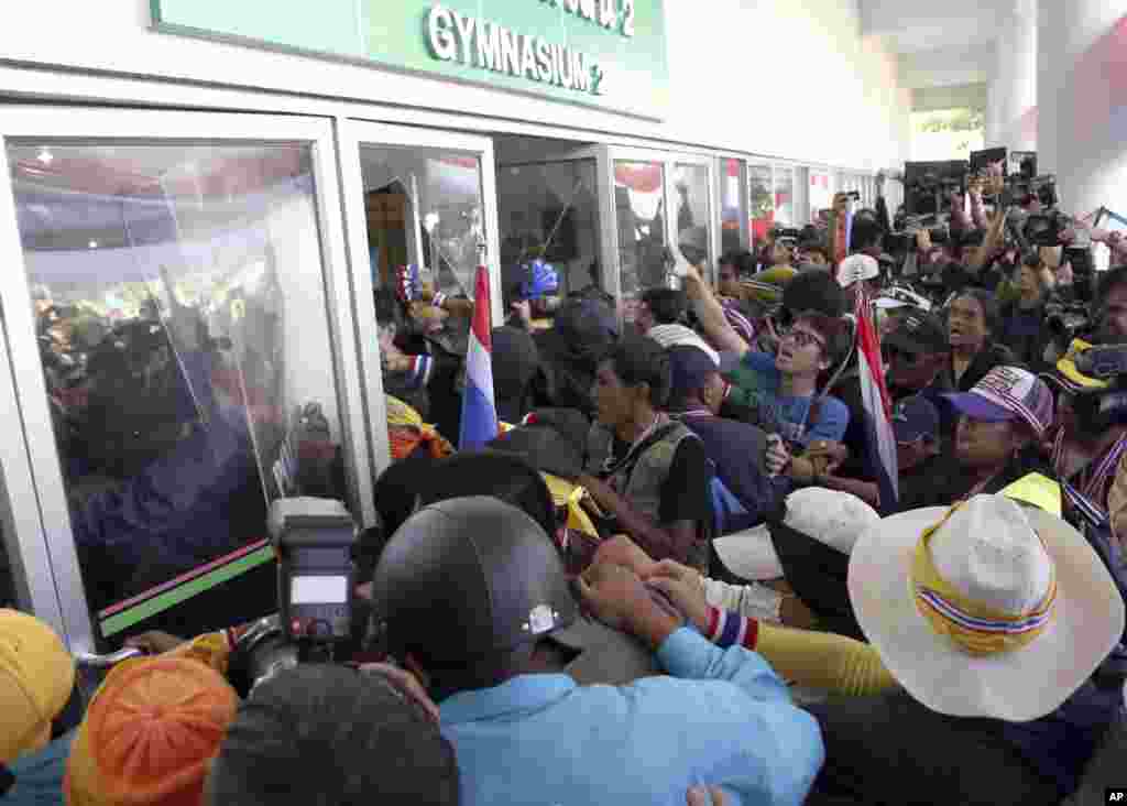 Anti-government protesters storm a sports gymnasium in an attempt to disrupt the election registration in Bangkok, Dec. 25, 2013. 