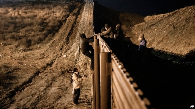 洪都拉斯移民越过边境围栏，试图从墨西哥蒂华纳跳入美国圣地亚哥。（2018年12月25日）