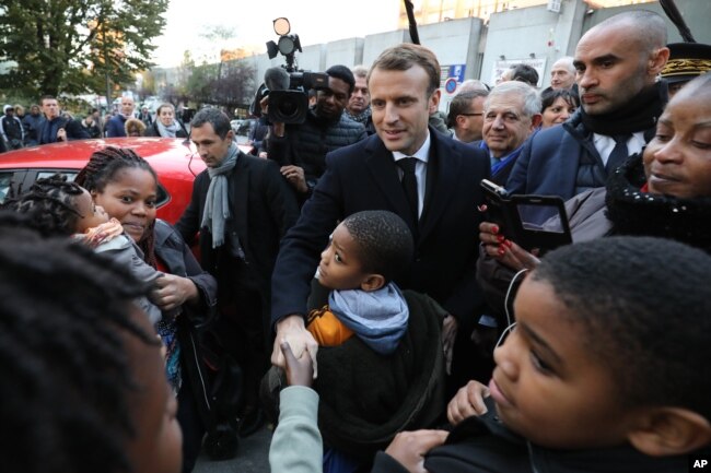 French President Emmanuel Macron, center, meets residents of the Cite du Chene Pointu during his visit focused on the theme of urban planing in Clichy-sous-Bois, Nov. 13, 2017.