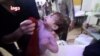 Một em bé khóc đang được lau mặt ngay sau vụ tấn công bị cáo buộc là bằng vũ khí hóa học ở Douma, Syria (ảnh tư liệu ngày 8/4/2018).