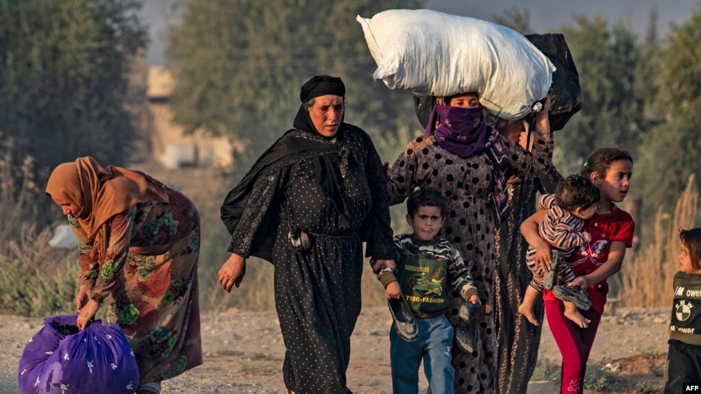 Civiles huyen durante el bombardeo turco en la ciudad de Ras al-Ain, en el noreste de Siria, en la provincia de Hasakeh, a lo largo de la frontera turca, el 9 de octubre de 2019.