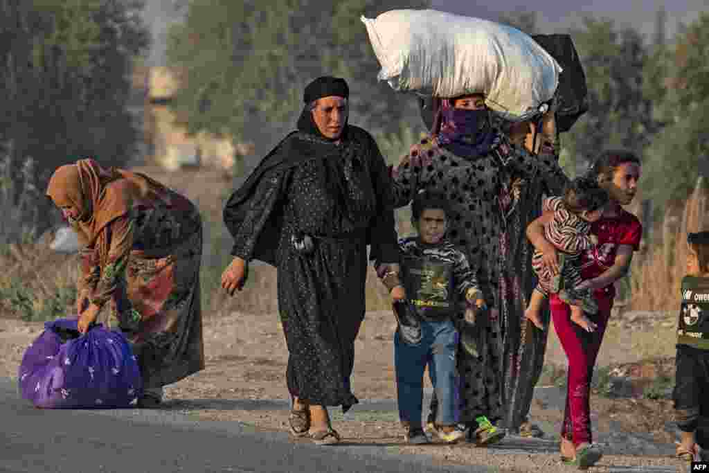 Civilians flee during Turkish bombardment on Syria&#39;s northeastern town of Ras al-Ain in the Hasakeh province along the Turkish border.