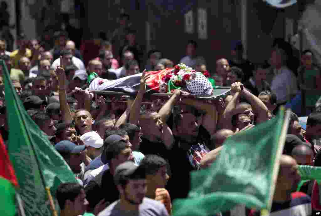 Palestinians carry the body of Mohammed al-Araj during his funeral in the Qalandia refugee camp near the West Bank city of Ramallah, July 25, 2014.