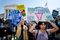 FILE - Abortion rights demonstrators including Jaylene Solache, of Dallas, Texas, right, rally, Wednesday, March 4, 2020, outside the Supreme Court in Washington. (AP Photo/Jacquelyn Martin)