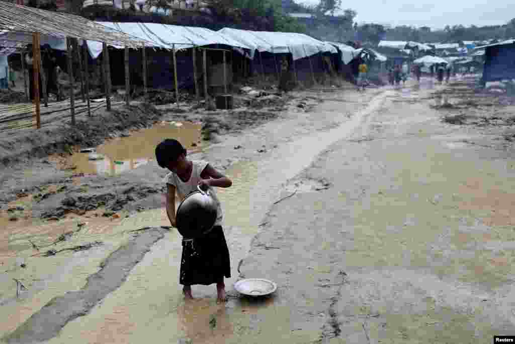 A Rohingya refugee child washes cooking utensils in the Balukhali refugee camp in Cox&#39;s Bazar, Bangladesh.