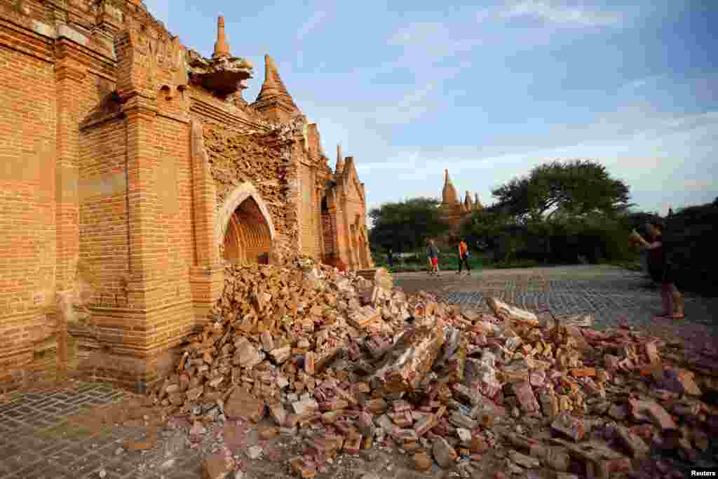 មនុស្សដើរកាត់វត្តខូចខាតក្រោយការរញ្ជួយដីក្នុងតំបន់ Bagan ថ្ងៃទី២៥ ខែសីហា ឆ្នាំ២០១៦។ 