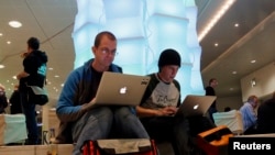 Dua orang pengguna komputer Apple tengah menjelajah internet di jeda waktu kongres komunikasi ke-29 yang diadakan sebuah klub komputer di Hamburg (Foto: dok). Apple menjadi sasaran terbaru peretas komputer bulan ini. 
