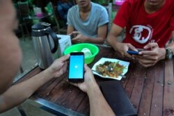 This photo taken on December 18, 2018 shows a Myanmar man logging into his Facebook account at a teashop in Yangon. - Facebook has removed hundreds of additional pages and accounts in Myanmar with hidden links to the military, the platform said on Decembe