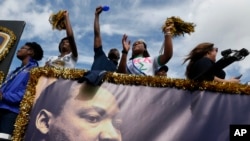 People aboard a float from Florida International University wave to crowds during a parade honoring Dr. Martin Luther King Jr. in the Liberty City neighborhood of Miami, Jan. 16, 2017.