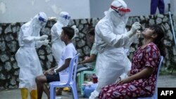 ရန်ကုန်မြို့ရှိ Quarantine Center တခုတွင် COVID ရှိ၊ မရှိ စစ်ဆေးပေးနေသည့် PPE ဝတ်စုံဝတ် ကျန်းမာရေးဝန်ထမ်းများ။ (အောက်တိုဘာ ၀၈၊ ၂၀၂၀)