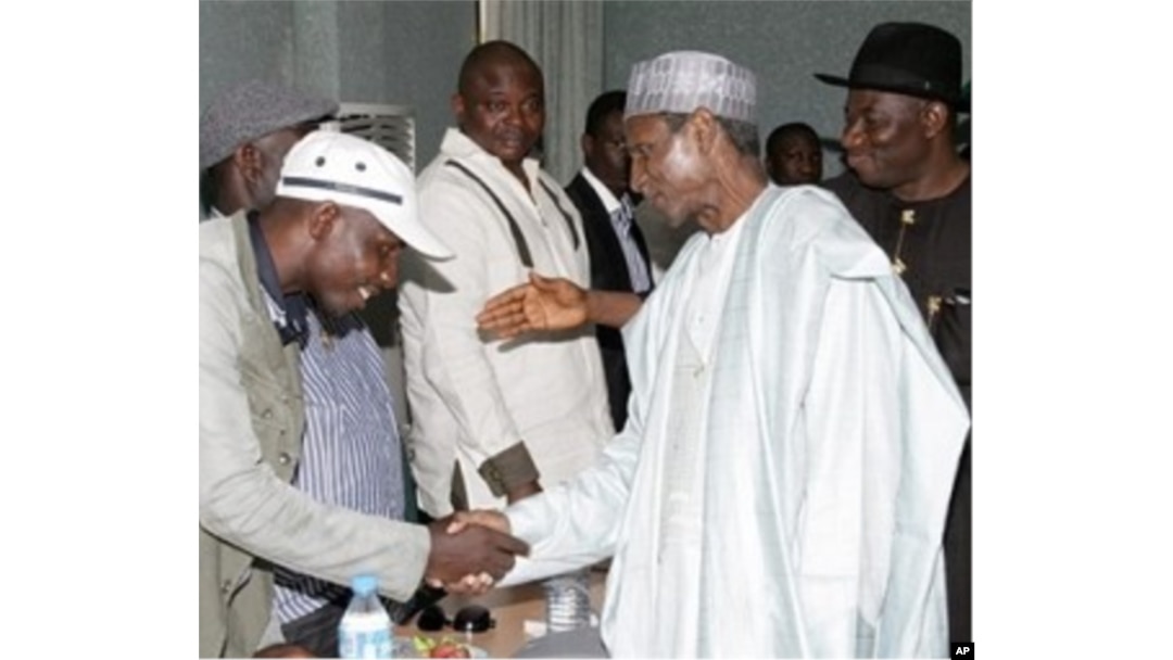 President Yar'Adua (C), flanked by then-Vice President Goodluck Jonathan (R), shakes hands with Government Ekpemupolo (L), commander of rebel group MEND, during their meeting in Abuja on 09 October 2009.