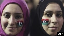 Alaa Elshiekh, right, and her sister Yosev Elshiekh, celebrate the revolution against Moammar Gadhafi's regime and ask for more women's rights in Tripoli, Libya, Friday, Sept. 2, 2011. 