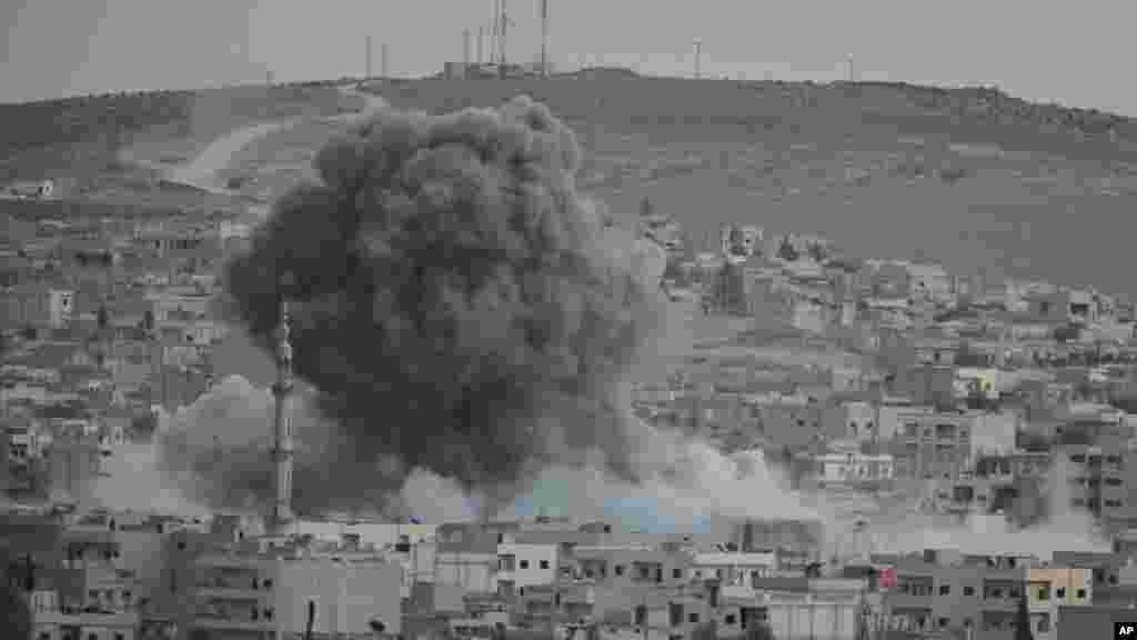 Thick smoke and debris rise from an airstrike by the U.S.-led coalition in Kobani, Syria, while fighting continued between Syrian Kurds and the militants of Islamic State group, as seen from Mursitpinar on the outskirts of Suruc, at the Turkey-Syria borde