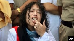 Aktivis HAM Irom Sharmila mengakhiri mogok makan dengan menjilat madu dari tangannya di imphal, negara bagian Manipur, India, hari Selasa (9/8). 