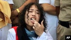 Indian political activist Irom Sharmila licks honey from her hand to break her fast in Imphal, north-eastern Indian state of Manipur, India, Aug. 9, 2016. One of India's most prominent political activists ended a 16-year hunger strike Tuesday.