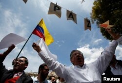 Supporters of the peace deal signed between the government and Revolutionary Armed Forces of Colombia rebels display a Colombian flag during a rally in front the Narino Palace, in Bogota, Colombia, Oct. 5, 2016. The placards read "Peace."