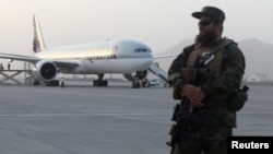 Seorang anggota pasukan keamanan Taliban siaga di depan sebuah pesawat "Qatar Airways" di bandara Hamid Karzai, Kabul, Afghanistan (10/9). 
