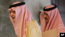 FILE - Saudi Foreign Minister Prince Saud Al Faisal, left, arrives with an unidentified aid for discussions with Catherine Ashton and the foreign ministers of EU and five other Arab countries.